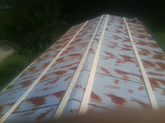 Rusted metal roof panels with new wood purlins before replacement — Storm Damage Roof Repair in Log Lane Village by Roofing Brothers