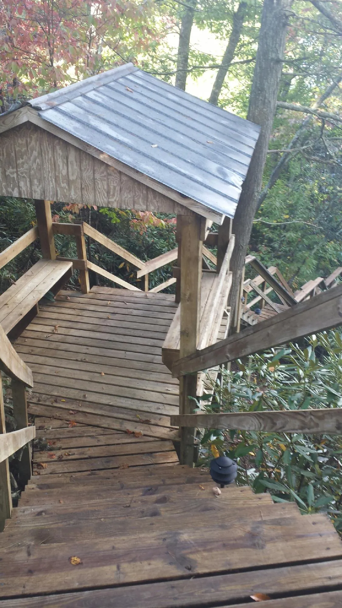 Metal roofed shelter over wooden steps on a wooded walkway — Skylight Repair & Installation work by our crew in Log Lane Village