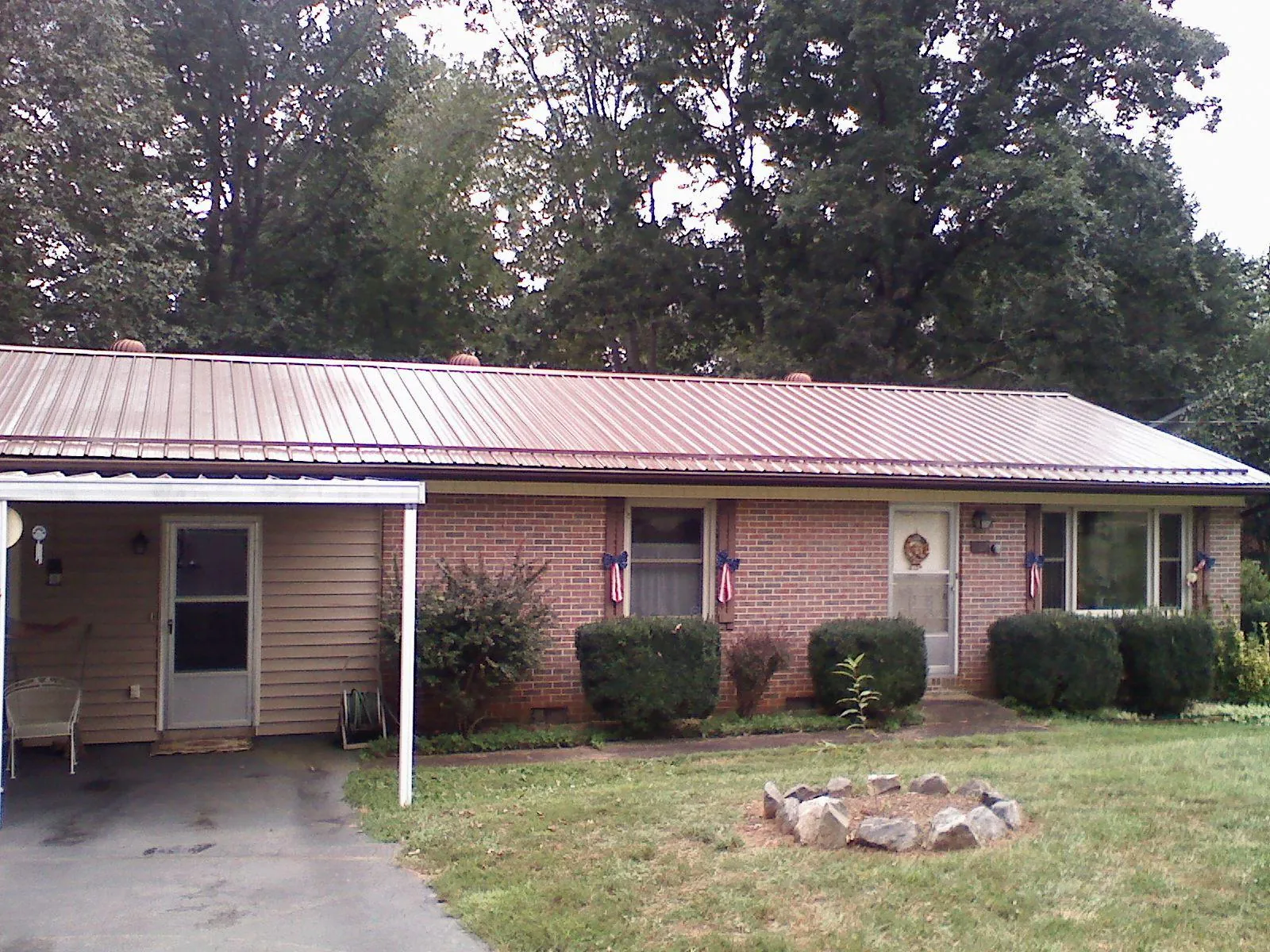 Bronze metal roof and carport on a brick ranch home — Roof Repair work by our crew in Log Lane Village